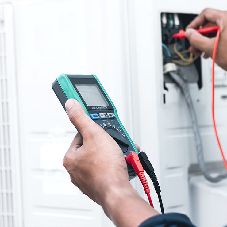 HVAC technician performing AC maintenance and electrical testing in Maryland