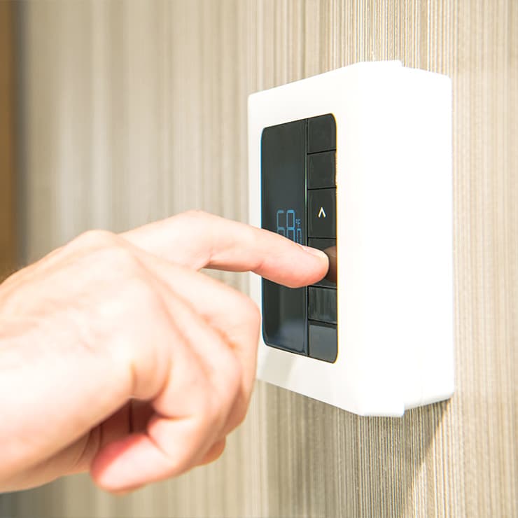 Homeowner adjusting an HVAC zoning control for room-by-room comfort in Maryland